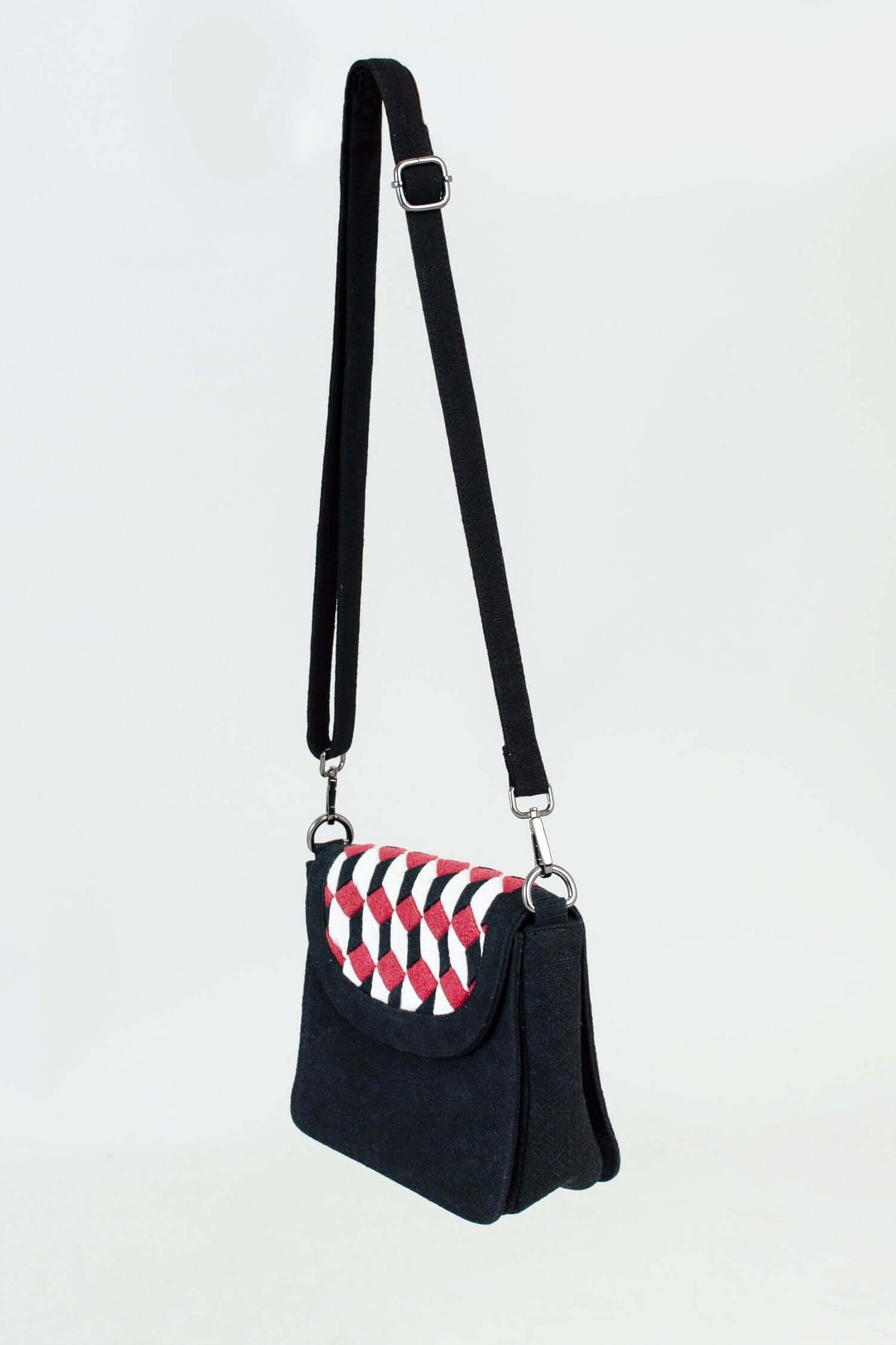 Side angle of black crossbody bag with geometric red, white, and black pattern