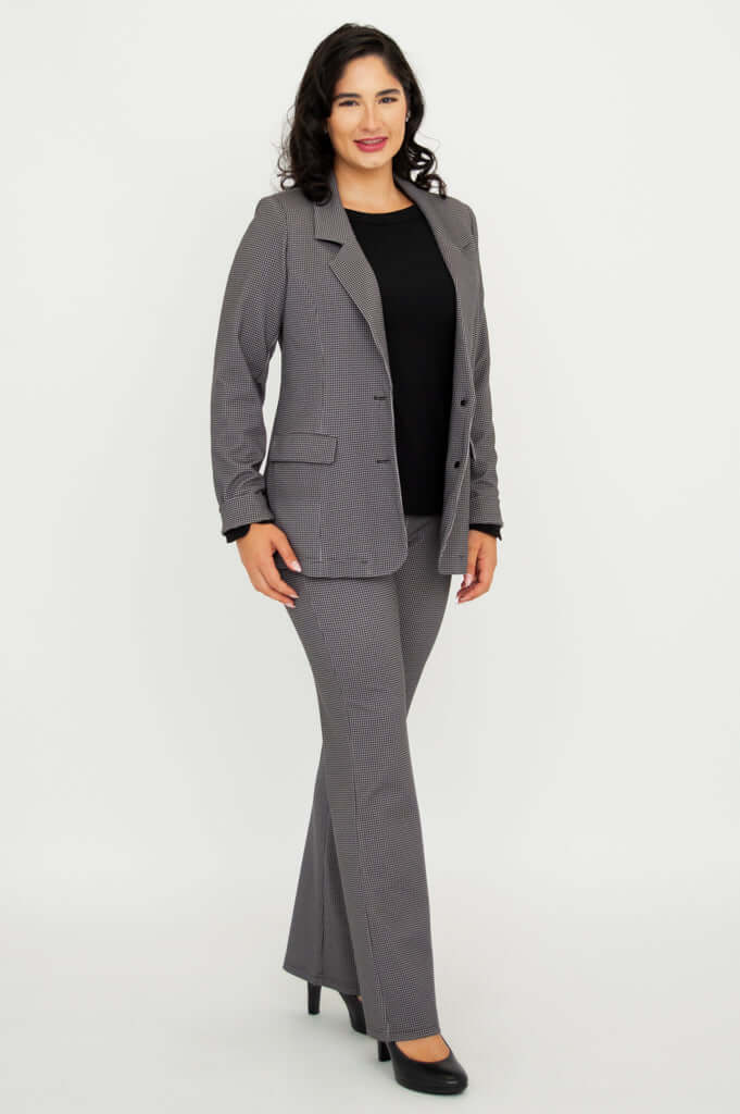 Side angle of a woman in checkered suit jacket and pants, wearing black heels