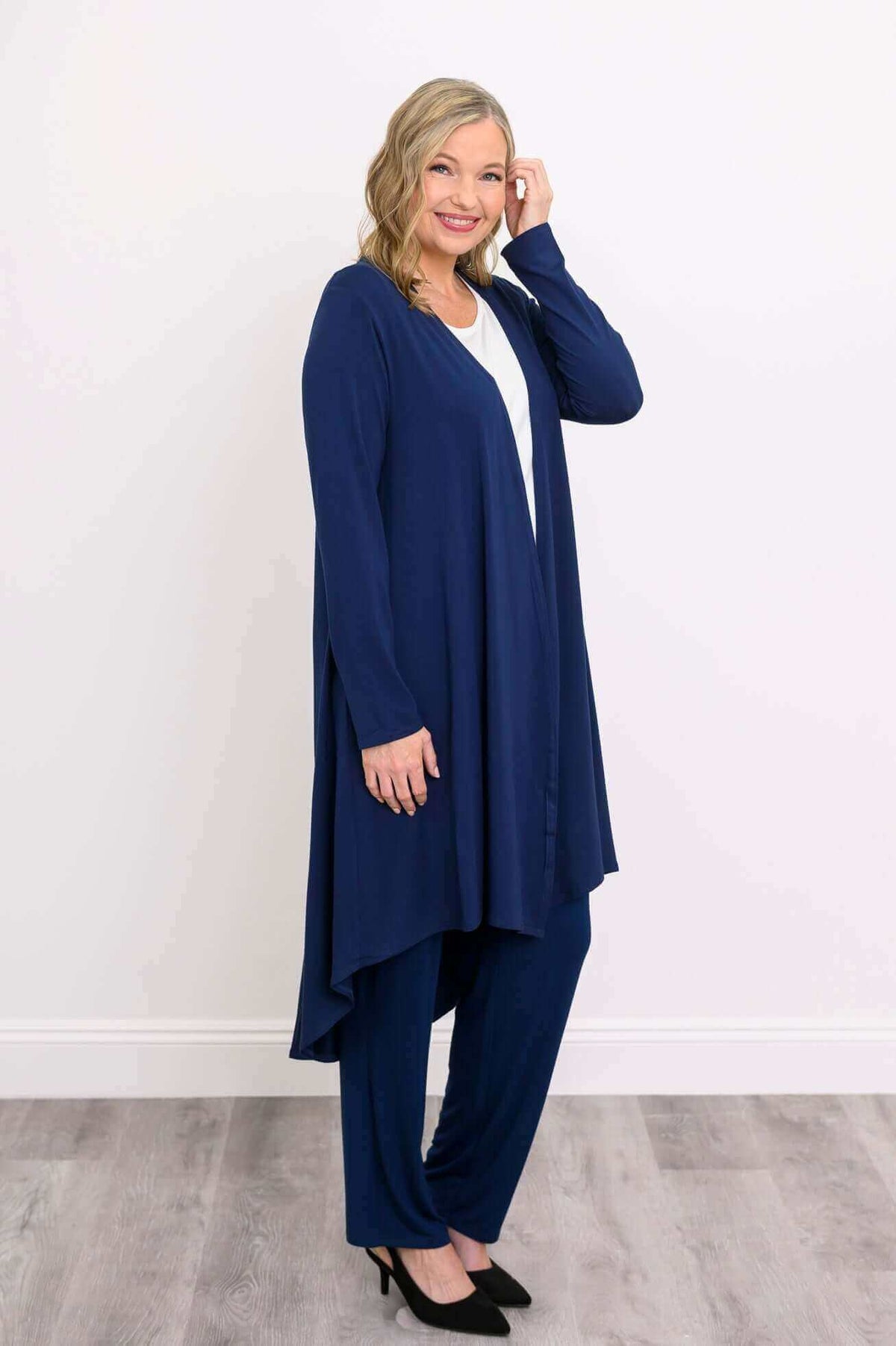 Side view of model in navy high-low cardigan-style duster with relaxed fit design
