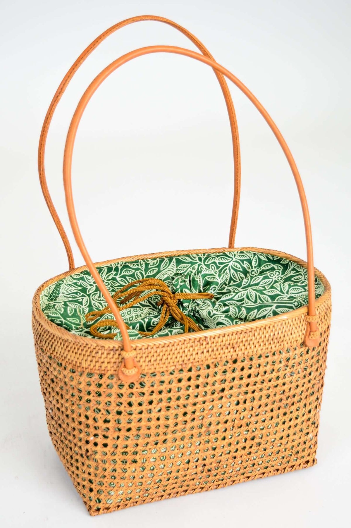 Side angle of rattan basket displaying the green print and secure handles