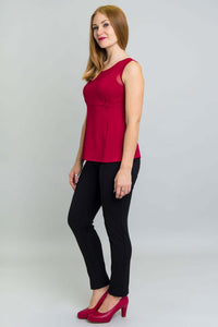Side view of woman wearing red mesh detail tank top with black pants