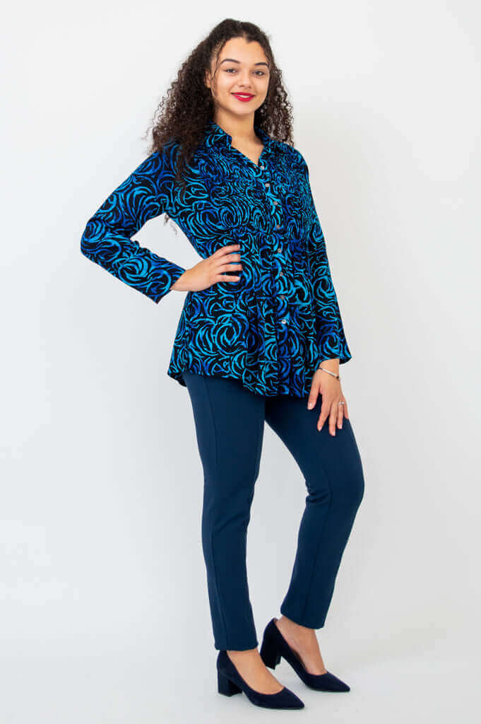 Side angled view of Cindy smocked blue swirl shirt styled with navy pants