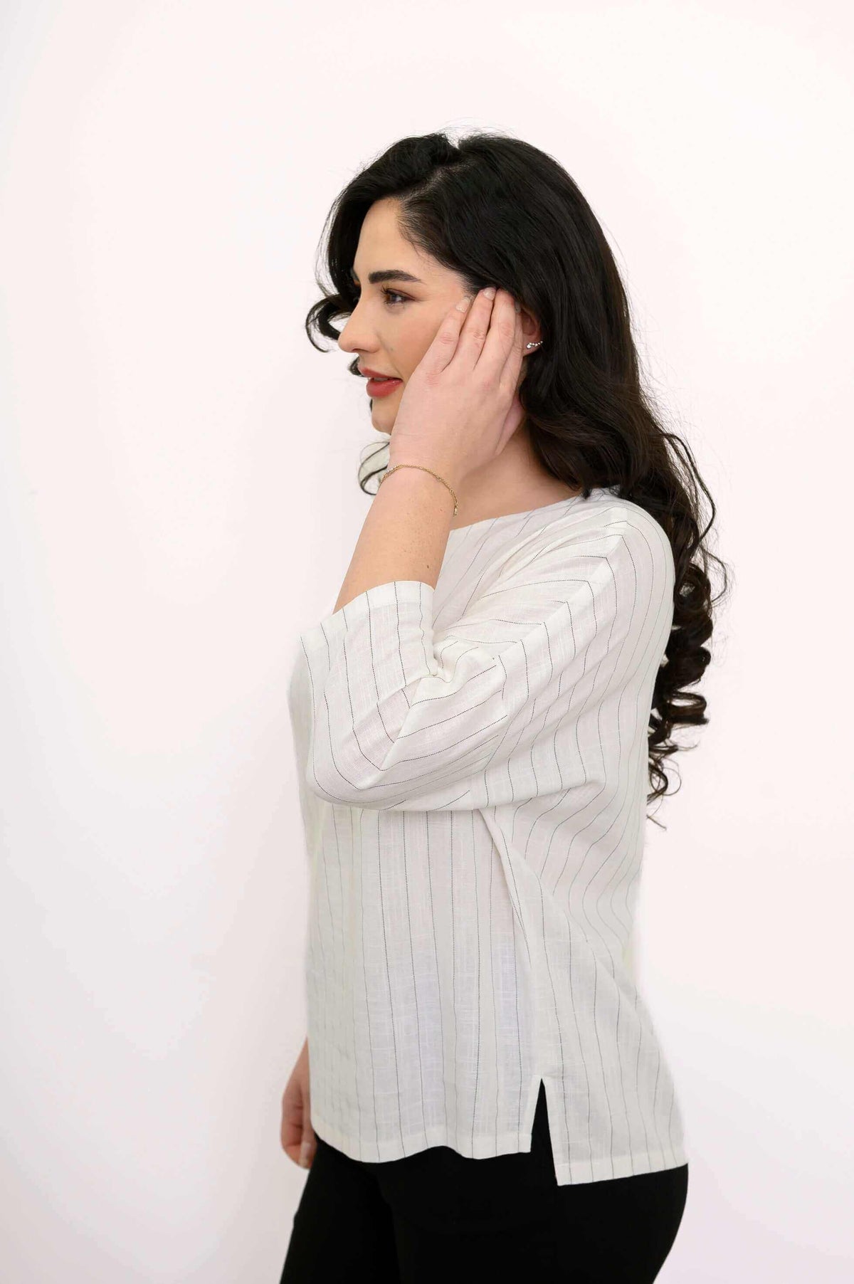Side view of white pinstripe top with high-low hem and side slit