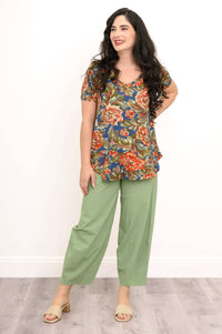 Side facing woman smiling in a floral Jackie Bamboo V-Neck Top and green pants
