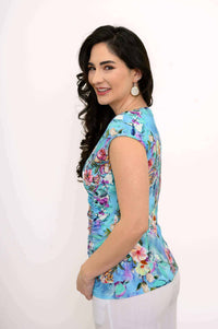 Side view of woman in blue floral faux wrap tank top, smiling