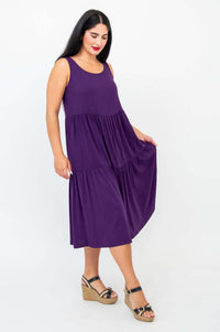 Side view of woman holding skirt of plum tiered dress