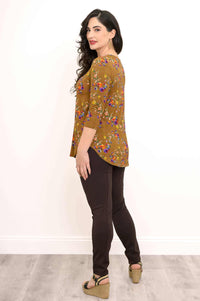 Side view of woman modeling marigold floral V-neck bamboo top