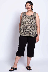 Model posing with hand in pocket, wearing black and tank abstract print tank top and black bottoms