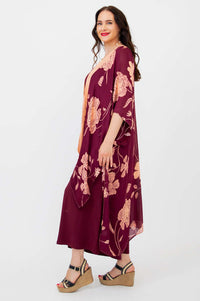Side profile of woman in burgundy peach floral kimono wrap with flowing sleeves