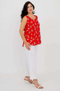Side view of woman in red floral sleeveless tank top and white pants