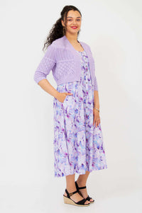 Side view of model in lilac pointelle knit cropped cardigan and watercolor midi dress