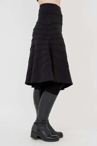 Side profile of Beverly skirt in black, highlighting the unique hem and wide waistband