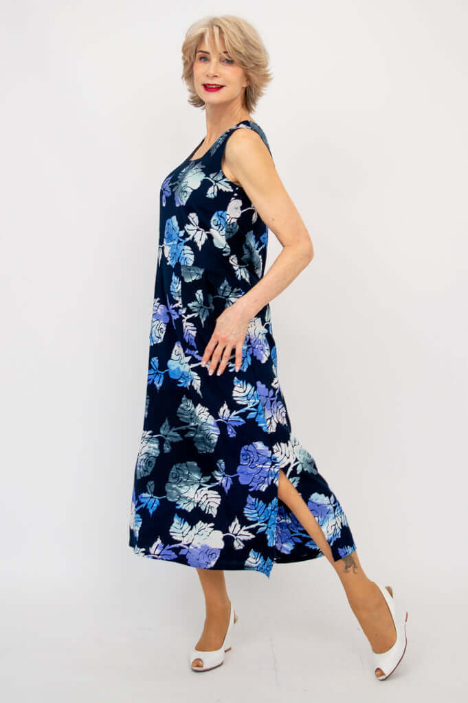 Side view of woman in blue floral dress with slit, showing movement and pockets