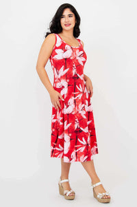 Side view of woman in red floral tank dress with hands in pockets