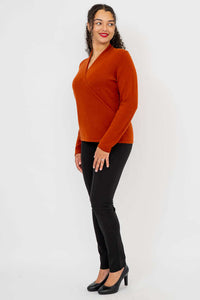 Side view of model wearing rust surplice sweater