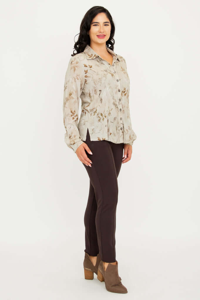 Side view of woman in beige floral button-up blouse with brown pants