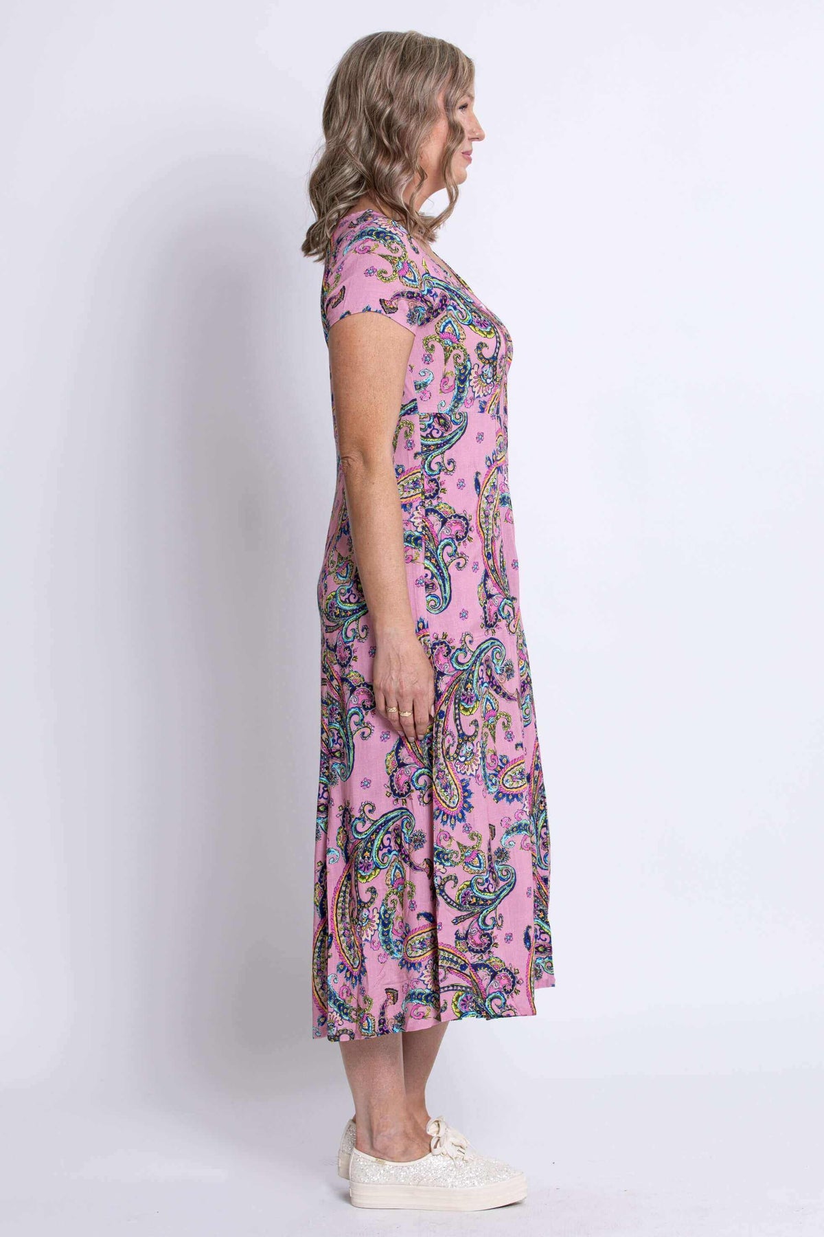 Side profile of woman in pink paisley midi dress
