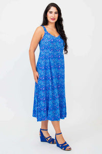 Woman posing in side view wearing sleeveless blue A-line midi dress