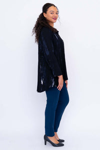 Side view of model showcasing the asymmetrical hem and drape of the black tunic top