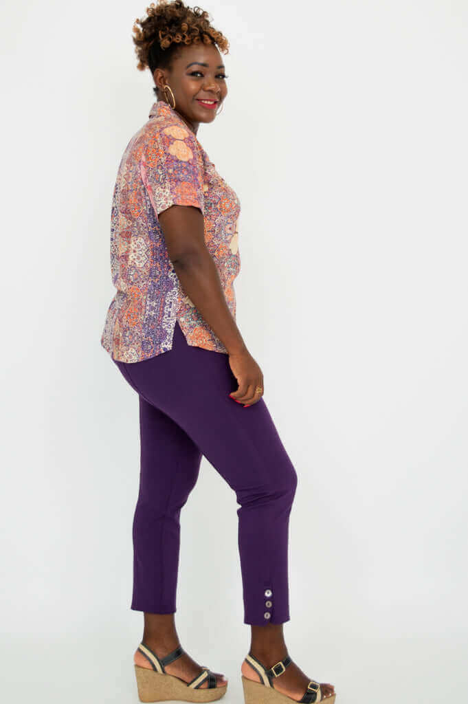 Side view of woman modeling boho mosaic print shirt and purple pants
