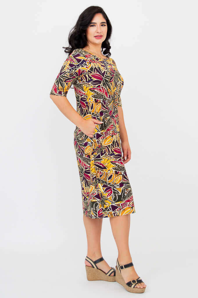 Side profile of woman in Olivia Tropikal print dress, showing pockets and relaxed fit