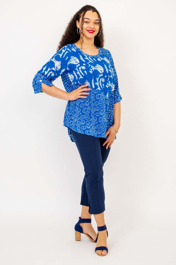 Woman in blue Palace Blouse with hand on hip, showing 3/4 sleeves and relaxed fit, navy pants