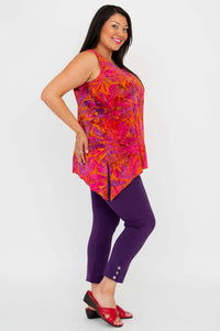 Side view of a model in orange and pink sleeveless V-neck top and purple pants