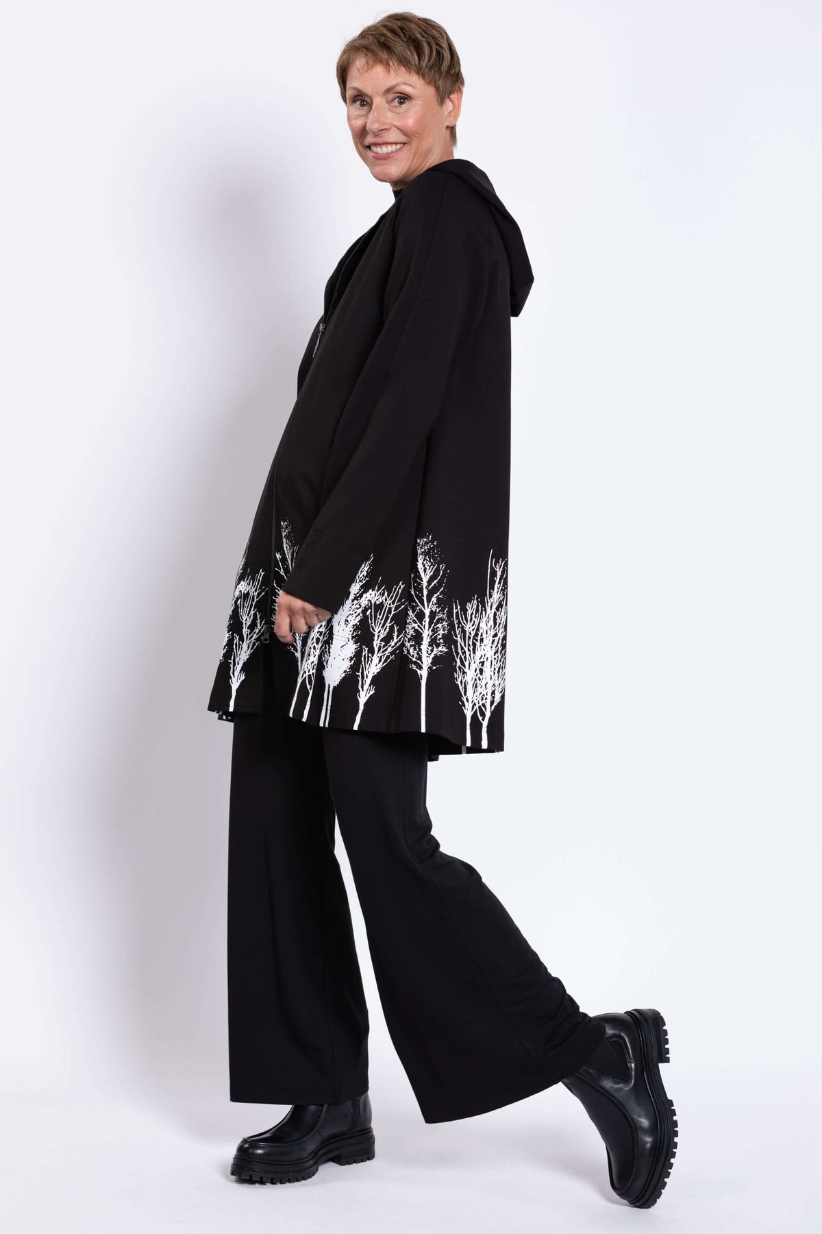 Side view of Edith Coat with hood and striking white tree print near hem