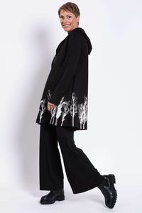 Side view of Edith Coat with hood and striking white tree print near hem