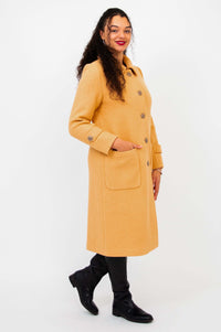 Side profile of model in Edna wool blend coat with her hand in a patch pocket