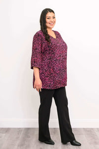 Side view of woman in Evelyn Top and black pants, smiling