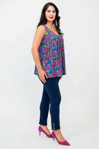Side view of model in colorful Peachy pleated tank top and navy slim-fit pants