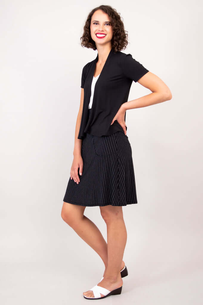 Side view of woman in a black short sleeve open jacket and pinstripe skirt