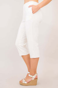 Side view of woman showcasing the fit and pockets of white Susan Capri pants