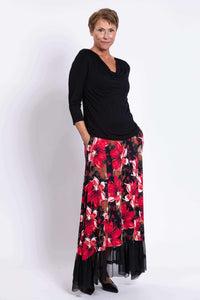Side angled view of woman in black top and red floral Vera Maxi Skirt with pockets and mesh hem