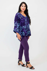 Side angle of purple bamboo print tunic top paired with purple pants and block heel sandals
