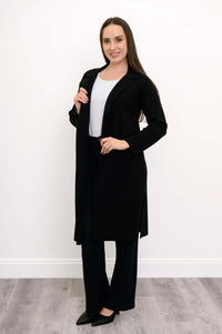 Side view of model wearing black open front knit jacket with large pockets