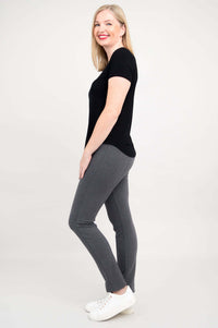 Side view of woman in black scoop neck tee and grey pants