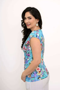Woman in blue floral Nova Tank turning to the side, showing cap sleeves and fitted silhouette