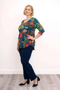 Side view of a woman wearing a blue floral V-neck top and navy pants with heels