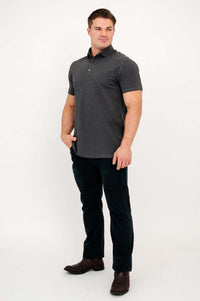 Side view of man wearing a dark grey bamboo polo shirt and black pants