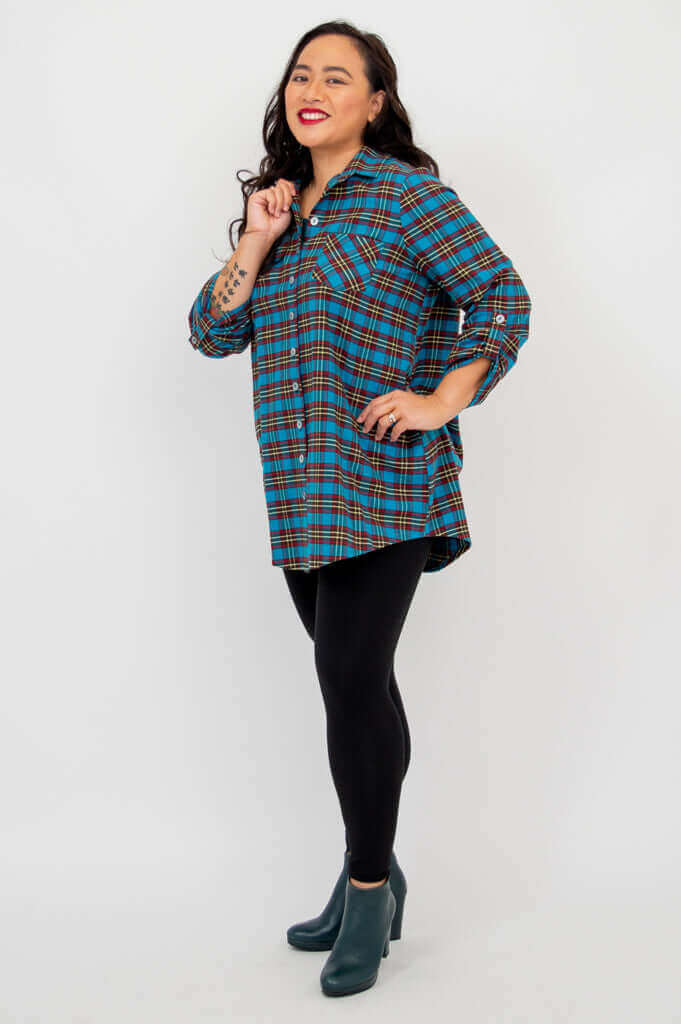 Side view of model in blue plaid tunic, smiling and holding collar
