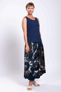 Angled view of model in tie dye batik skirt, showing rounded hem and airy fit