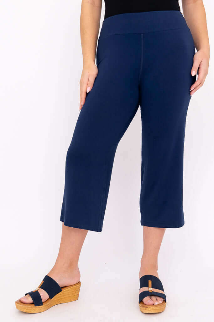 Side view of a model in navy blue bamboo yoga capri pants