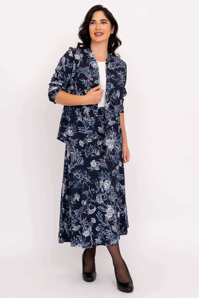 Model in side view, wearing a navy floral jacket and matching midi skirt