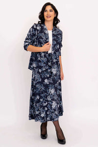 Model in side view, wearing a navy floral jacket and matching midi skirt