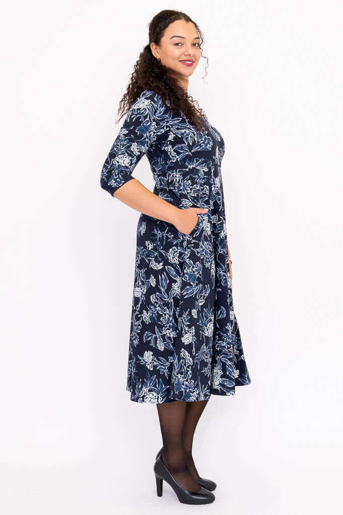 Side view showing pockets of navy floral midi dress with 3/4 sleeves