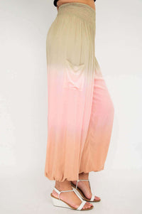 Side view of ombre pants with pocket, peach and pink gradient and gathered cuffs