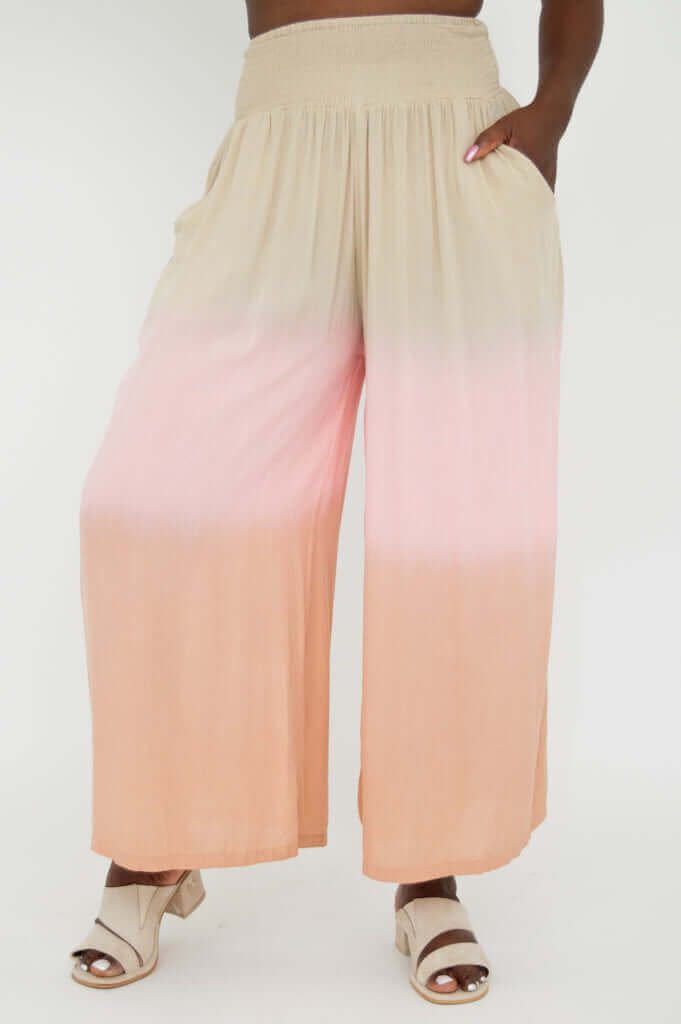 Side view of peach and beige ombre wide leg pants with pockets