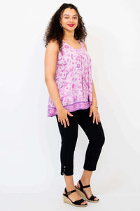 Side view of model in pink floral pleated tank top and black pants